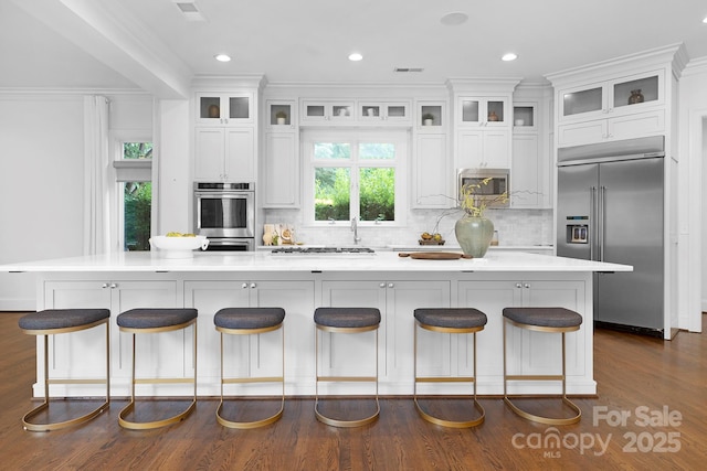 7912 Baltusrol Ln, Charlotte, NC 28210 - kitchen with appliances with stainless steel finishes, white cabinets, decorative backsplash, ornamental molding, and recessed lighting