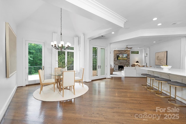 7912 Baltusrol Ln, Charlotte, NC 28210 - dining area featuring a fireplace, a chandelier, dark wood finished floors, recessed lighting, and ornamental molding