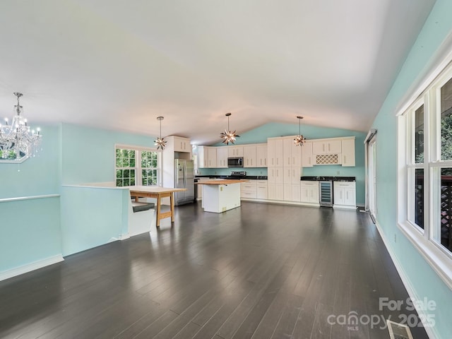 14 Spring Lake Dr, Fletcher, NC 28732 - unfurnished living room featuring a chandelier, beverage cooler, lofted ceiling, and dark wood-type flooring