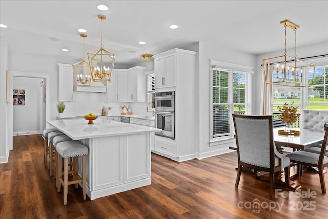 615 N Oak Dr, Huntersville, NC 28078 - kitchen with a chandelier, double oven, light countertops, plenty of natural light, and recessed lighting
