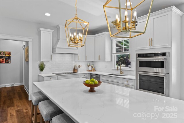 615 N Oak Dr, Huntersville, NC 28078 - kitchen with a chandelier, double oven, premium range hood, black electric cooktop, and decorative backsplash