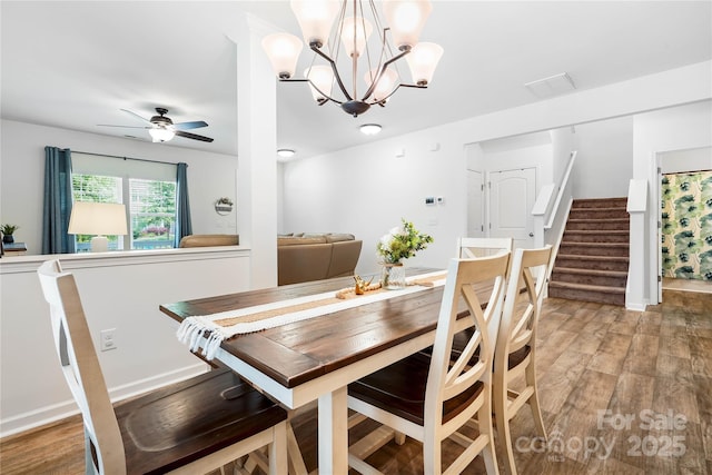 5069 Thomasville Dr, Belmont, NC 28012 - dining area with light wood-style floors, a ceiling fan, stairway, and a chandelier