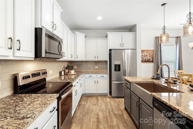 5069 Thomasville Dr, Belmont, NC 28012 - kitchen featuring appliances with stainless steel finishes, white cabinets, light wood-type flooring, and tasteful backsplash