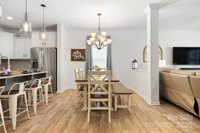 5069 Thomasville Dr, Belmont, NC 28012 - dining area with light wood-style flooring, a chandelier, and ornate columns