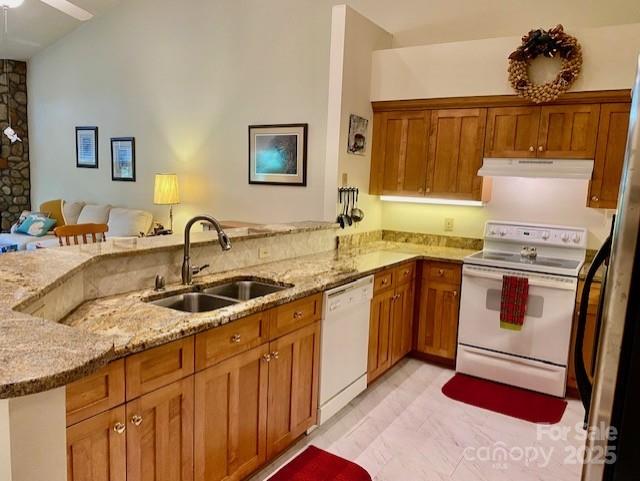 186 Stonecrest Ct, Lake Lure, NC 28746 - kitchen with white appliances, under cabinet range hood, brown cabinetry, and a peninsula
