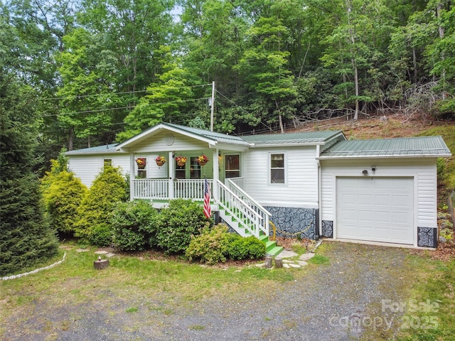 275 Bulldog Ln, Green Mountain, NC 28740 - view of front of property featuring covered porch, driveway, a garage, a metal roof, and stone siding