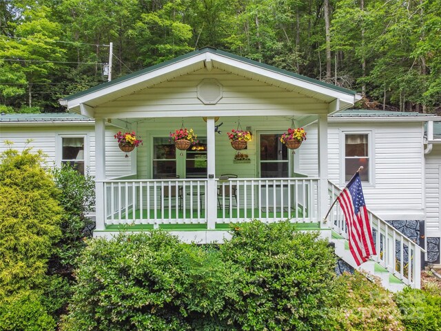 275 Bulldog Ln, Green Mountain, NC 28740 - bungalow with covered porch, a metal roof, and a wooded view