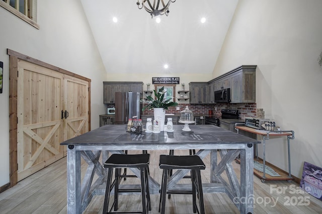 4592 Reid Rd, Edgemoor, SC 29712 - kitchen with freestanding refrigerator, black / electric stove, high vaulted ceiling, dark brown cabinetry, and backsplash