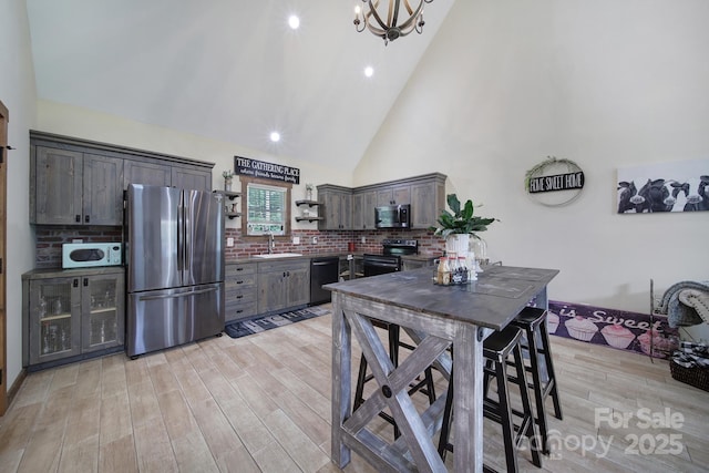 4592 Reid Rd, Edgemoor, SC 29712 - kitchen featuring appliances with stainless steel finishes, high vaulted ceiling, open shelves, light wood-style floors, and dark brown cabinets