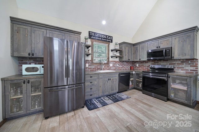 4592 Reid Rd, Edgemoor, SC 29712 - kitchen featuring stainless steel appliances, open shelves, light wood finished floors, vaulted ceiling, and dark brown cabinets