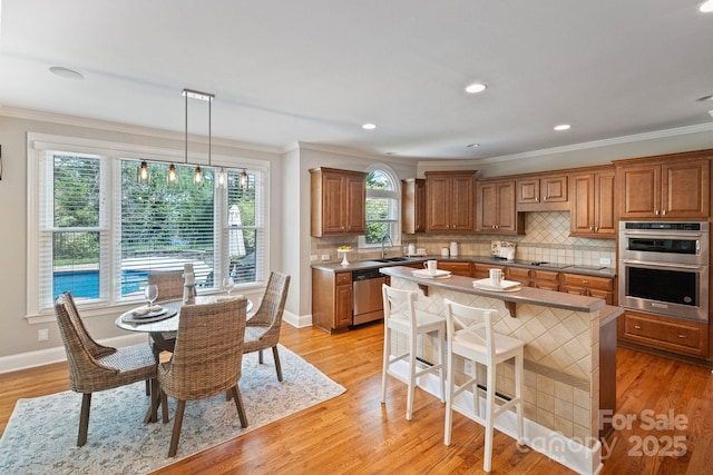 11335 Wescott Hill Dr, Huntersville, NC 28078 - kitchen featuring appliances with stainless steel finishes, ornamental molding, brown cabinets, backsplash, and recessed lighting