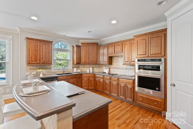11335 Wescott Hill Dr, Huntersville, NC 28078 - kitchen featuring stainless steel appliances, light wood-type flooring, brown cabinets, tasteful backsplash, and crown molding