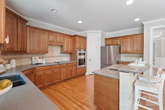 11335 Wescott Hill Dr, Huntersville, NC 28078 - kitchen with stainless steel appliances, light wood-type flooring, brown cabinetry, a breakfast bar area, and crown molding