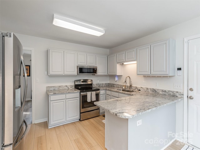 502 Windsor Forest Ct, Fletcher, NC 28732 - kitchen with appliances with stainless steel finishes, a peninsula, light wood-style flooring, light stone counters, and white cabinets