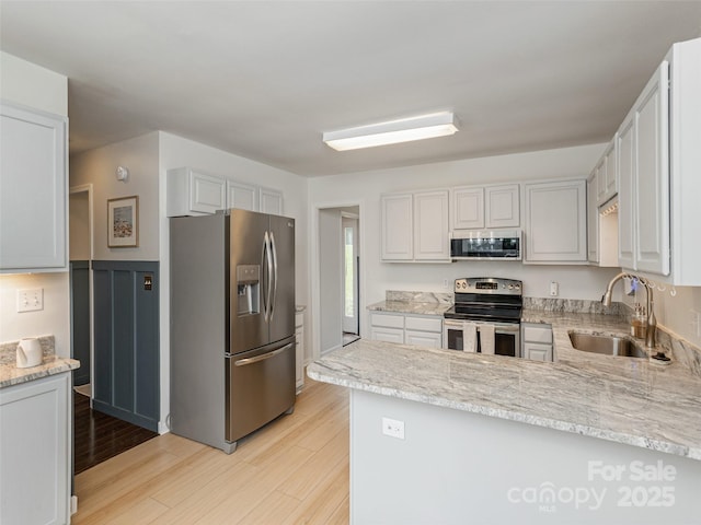 502 Windsor Forest Ct, Fletcher, NC 28732 - kitchen with stainless steel appliances, light wood-style floors, a peninsula, and light stone countertops