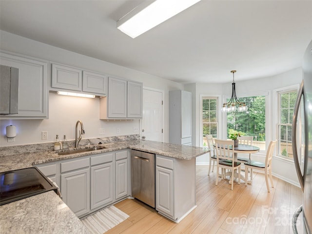 502 Windsor Forest Ct, Fletcher, NC 28732 - kitchen featuring stainless steel appliances, a peninsula, light wood-style flooring, a chandelier, and hanging light fixtures