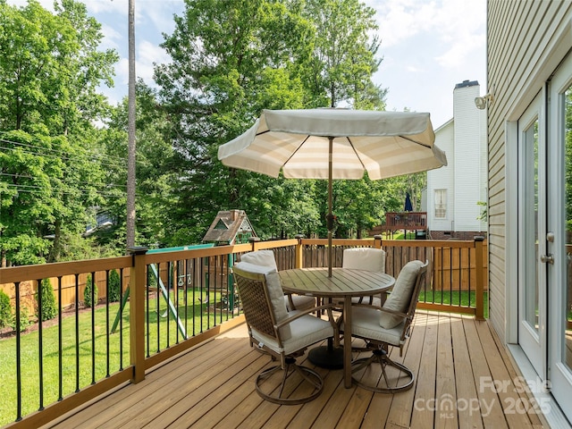 502 Windsor Forest Ct, Fletcher, NC 28732 - deck featuring a playground, outdoor dining area, a fenced backyard, and view of wooded area