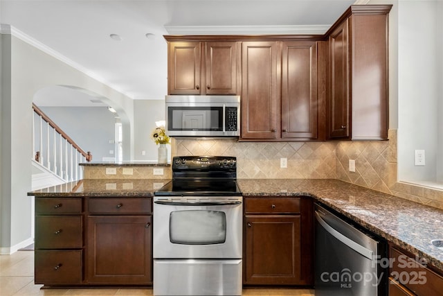 448 River Park Rd, Belmont, NC 28012 - kitchen with stainless steel appliances, a peninsula, dark stone counters, backsplash, and arched walkways