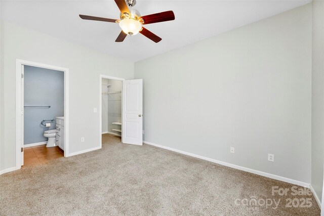448 River Park Rd, Belmont, NC 28012 - unfurnished bedroom featuring carpet, a walk in closet, a closet, connected bathroom, and a ceiling fan