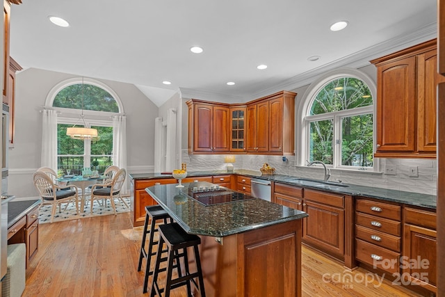 1317 Longleaf Ct, Matthews, NC 28104 - kitchen featuring black electric stovetop, dishwasher, brown cabinets, a kitchen bar, and lofted ceiling