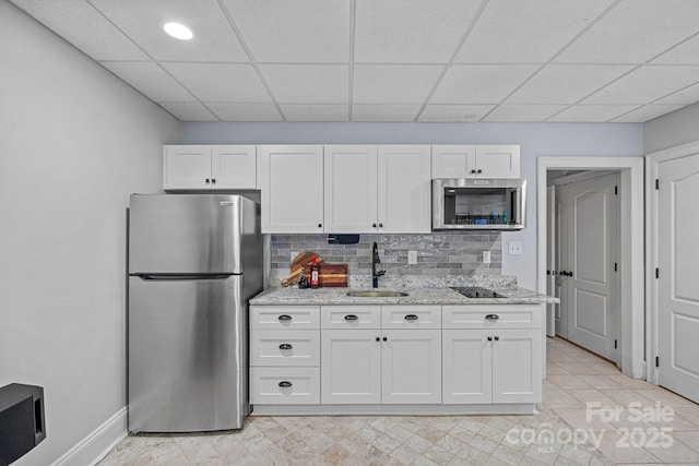 1317 Longleaf Ct, Matthews, NC 28104 - kitchen with appliances with stainless steel finishes, a drop ceiling, white cabinets, light stone countertops, and backsplash