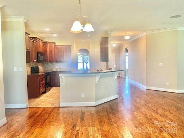 1302 Devonmere Pl, Salisbury, NC 28144 - kitchen with black appliances, arched walkways, plenty of natural light, a breakfast bar area, and crown molding