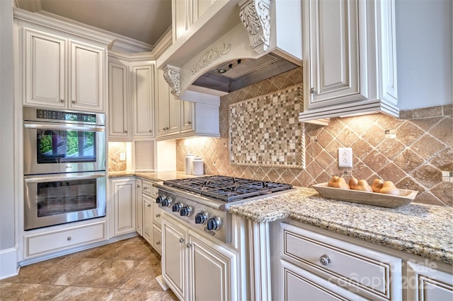 6216 N Rd, York, SC 29745 - kitchen featuring stainless steel appliances, premium range hood, cream cabinetry, light stone counters, and decorative backsplash