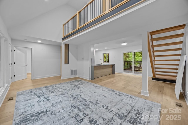 6501 Piney Path Rd, Charlotte, NC 28212 - unfurnished living room with light wood finished floors, stairs, high vaulted ceiling, and recessed lighting