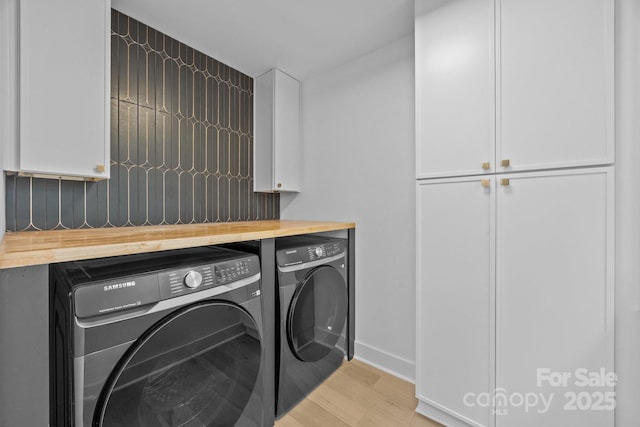 6501 Piney Path Rd, Charlotte, NC 28212 - washroom featuring washer and clothes dryer, light wood-type flooring, and cabinet space