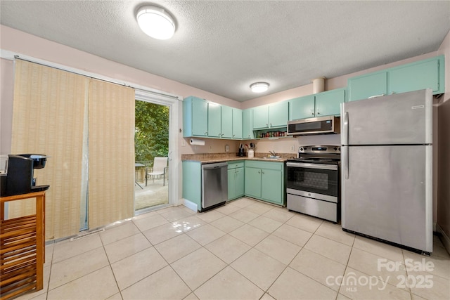 3130 Erskine Dr, Charlotte, NC 28205 - kitchen with appliances with stainless steel finishes, a textured ceiling, and light tile patterned flooring
