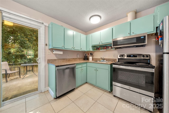 3130 Erskine Dr, Charlotte, NC 28205 - kitchen featuring appliances with stainless steel finishes, a textured ceiling, and light tile patterned flooring