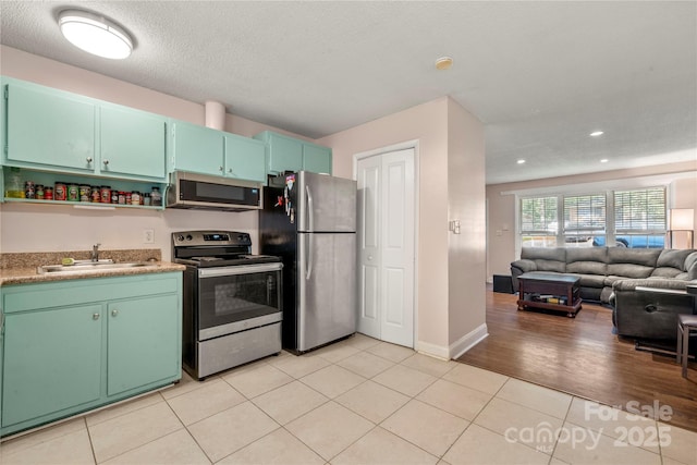 3130 Erskine Dr, Charlotte, NC 28205 - kitchen featuring stainless steel appliances, open floor plan, light tile patterned floors, open shelves, and recessed lighting