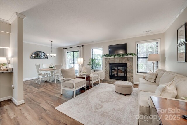 353 Tall Oaks Trl, Fort Mill, SC 29715 - living area with ornamental molding, wood finished floors, a fireplace, and a chandelier