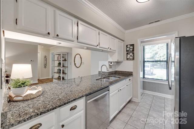 353 Tall Oaks Trl, Fort Mill, SC 29715 - kitchen with stainless steel appliances, white cabinetry, a textured ceiling, ornamental molding, and dark stone counters