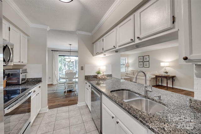 353 Tall Oaks Trl, Fort Mill, SC 29715 - kitchen with appliances with stainless steel finishes, dark stone counters, white cabinetry, ornamental molding, and tasteful backsplash