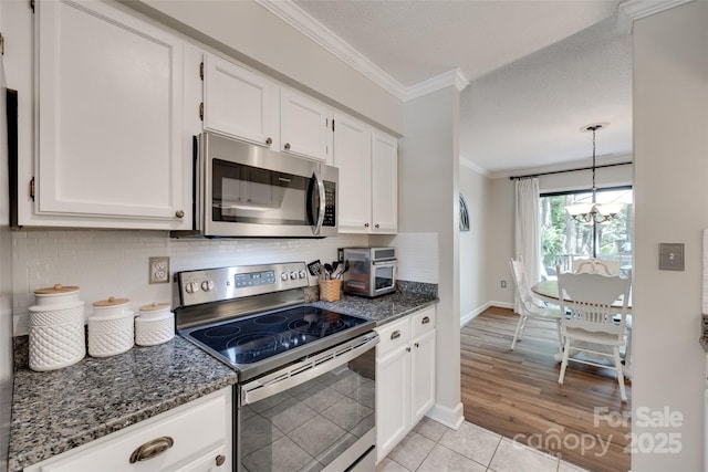 353 Tall Oaks Trl, Fort Mill, SC 29715 - kitchen featuring appliances with stainless steel finishes, crown molding, white cabinets, dark stone countertops, and backsplash