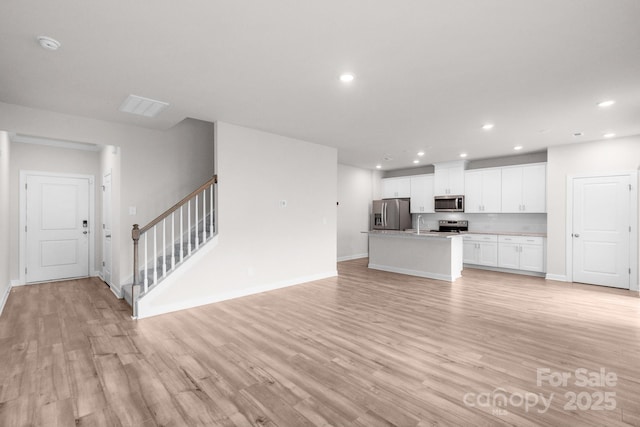 1022 Jeffery Dean Ct, Albemarle, NC 28001 - unfurnished living room featuring recessed lighting, light wood finished floors, and stairway