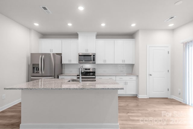 1022 Jeffery Dean Ct, Albemarle, NC 28001 - kitchen with stainless steel appliances, light wood finished floors, white cabinets, decorative backsplash, and recessed lighting