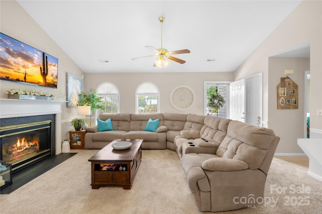 2490 Hawk Ridge Dr, Gastonia, NC 28056 - living room featuring vaulted ceiling, a ceiling fan, carpet flooring, and a fireplace with flush hearth