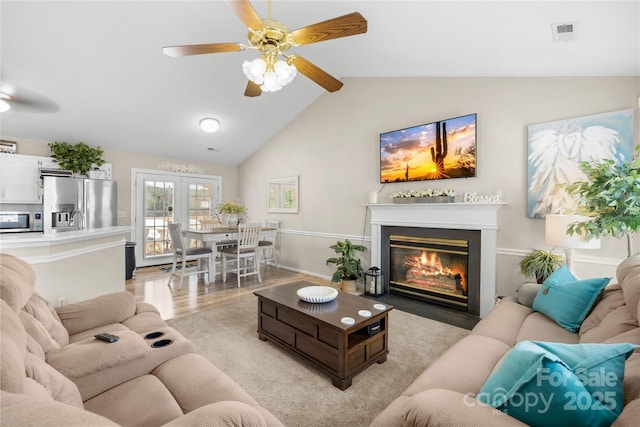 2490 Hawk Ridge Dr, Gastonia, NC 28056 - living room featuring a fireplace with flush hearth, a ceiling fan, light wood-style flooring, and high vaulted ceiling