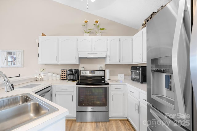 2490 Hawk Ridge Dr, Gastonia, NC 28056 - kitchen featuring appliances with stainless steel finishes, vaulted ceiling, under cabinet range hood, white cabinetry, and light countertops