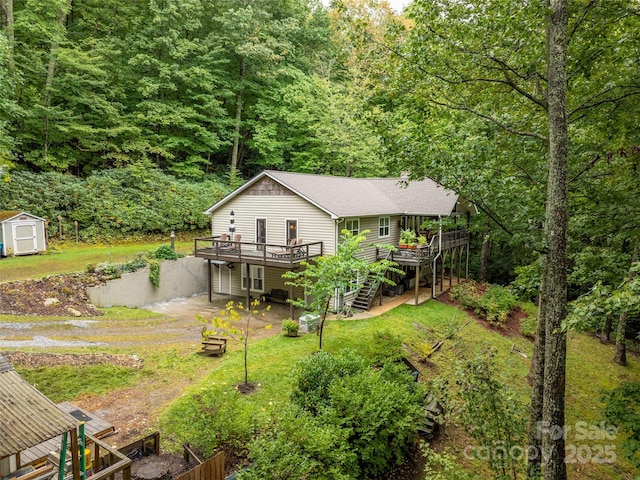 21 Fern Haven Ln, Fairview, NC 28730 - rear view of house with a storage shed, a deck, stairs, a view of trees, and a lawn