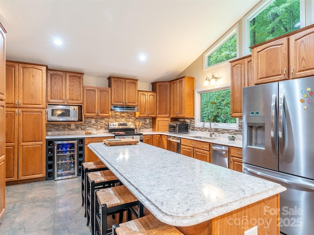 21 Fern Haven Ln, Fairview, NC 28730 - kitchen featuring appliances with stainless steel finishes, beverage cooler, a kitchen bar, tasteful backsplash, and vaulted ceiling