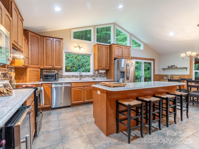 21 Fern Haven Ln, Fairview, NC 28730 - kitchen with appliances with stainless steel finishes, lofted ceiling, a center island, a breakfast bar area, and tasteful backsplash