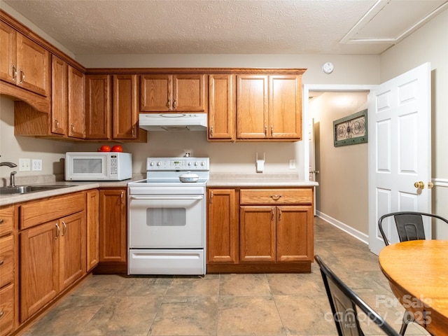 21 Fern Haven Ln, Fairview, NC 28730 - kitchen featuring white appliances, under cabinet range hood, light countertops, and brown cabinetry