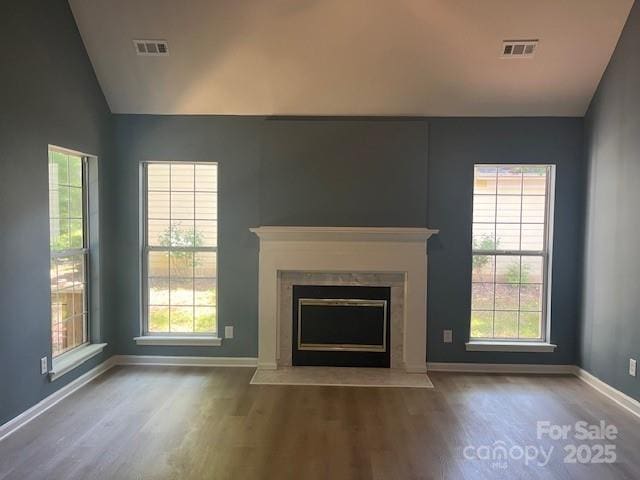 11021 Scrimshaw Ln, Charlotte, NC 28215 - unfurnished living room with vaulted ceiling, wood finished floors, a fireplace with flush hearth, and plenty of natural light