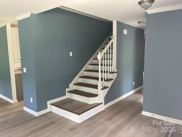 11021 Scrimshaw Ln, Charlotte, NC 28215 - staircase featuring wood finished floors and crown molding