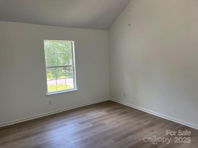 11021 Scrimshaw Ln, Charlotte, NC 28215 - spare room with wood finished floors and vaulted ceiling