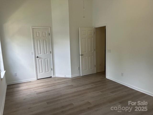 11021 Scrimshaw Ln, Charlotte, NC 28215 - unfurnished bedroom with dark wood-type flooring and a towering ceiling