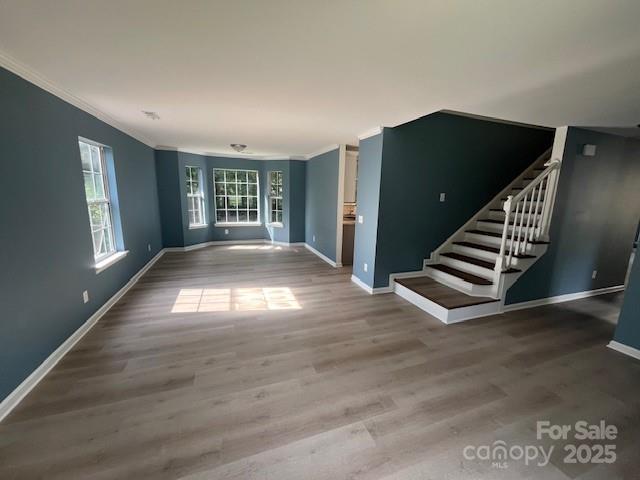 11021 Scrimshaw Ln, Charlotte, NC 28215 - spare room with ornamental molding, wood finished floors, and stairway